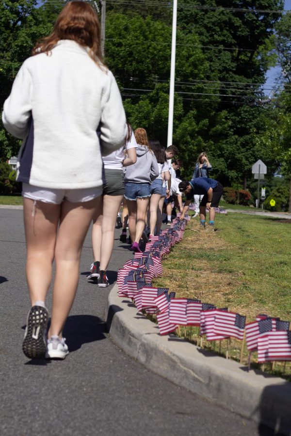 Students place flags in remembrance of soldiers who have served in the US Military.